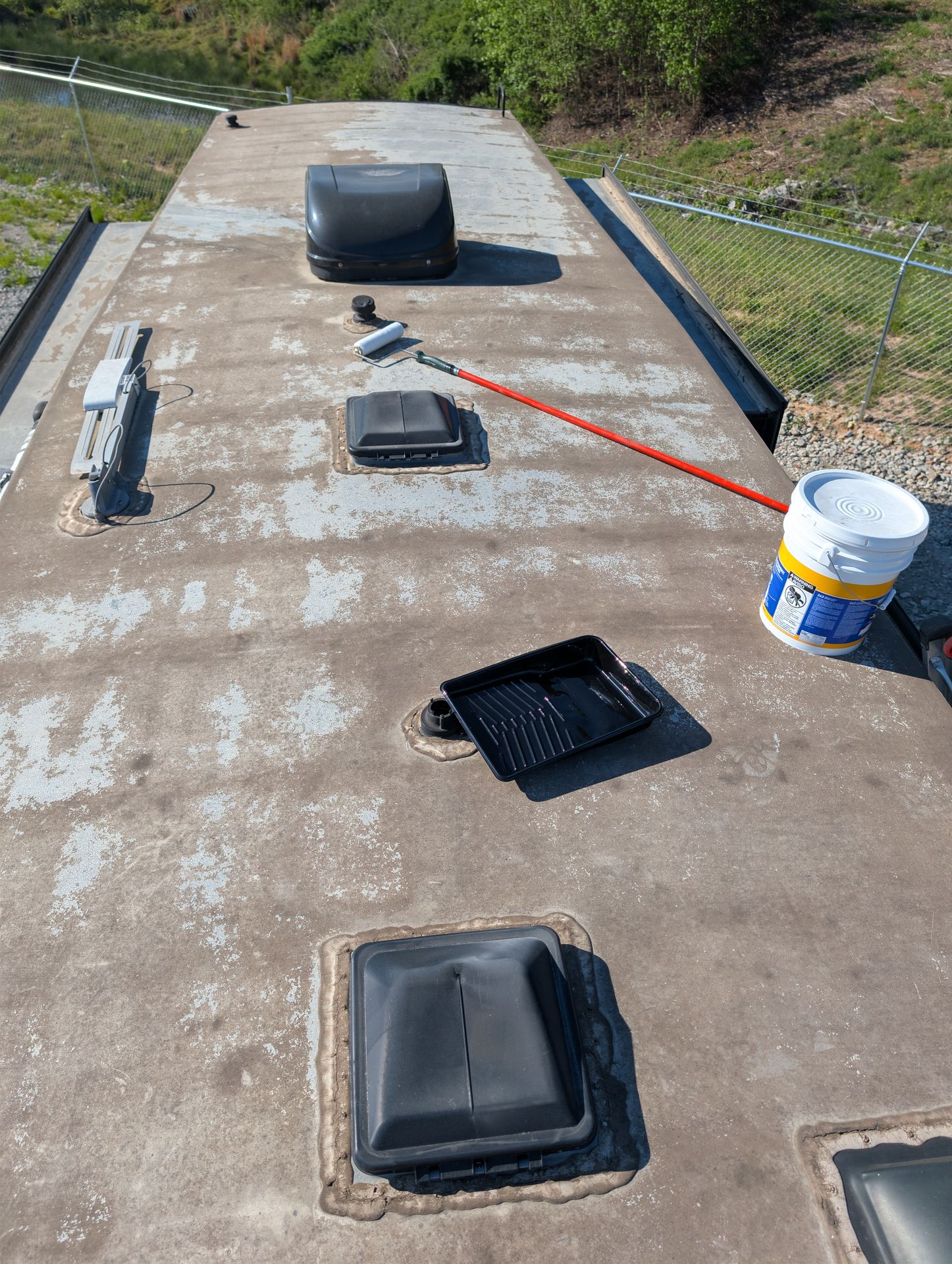 Protective coating being rolled onto an RV roof